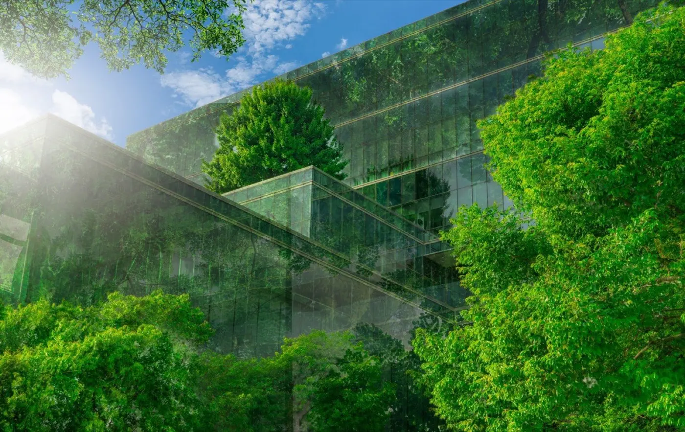 Verglaste Gebäudefassade mit dichter Begrünung – Sinnbild für energieoptimierte Immobilien